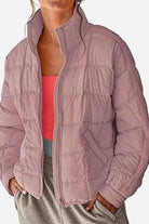 Lightweight puffer travel jacket displayed on a white background, showing its compact, travel-ready design and versatile style in black color.