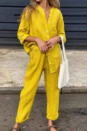 Woman wearing yellow casual chic two-piece set with button-up shirt and relaxed pants carrying white tote bag