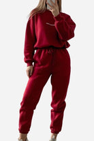 woman wearing red Storm Sweater Mock Neck athleisure set with relaxed fit and adjustable waist