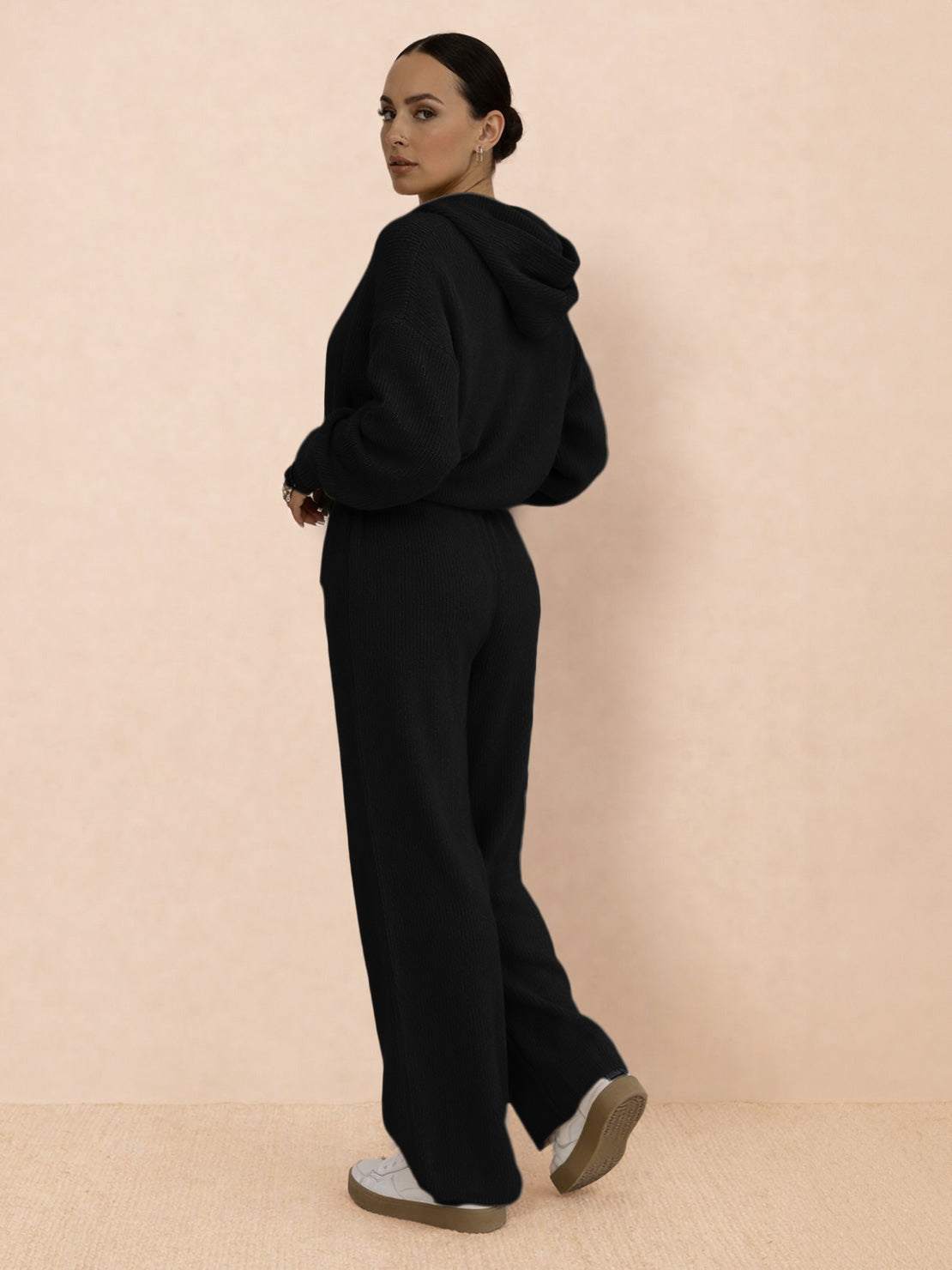 woman wearing black waffle-knit two-piece hoodie and pants set with relaxed fit and wide-leg pants