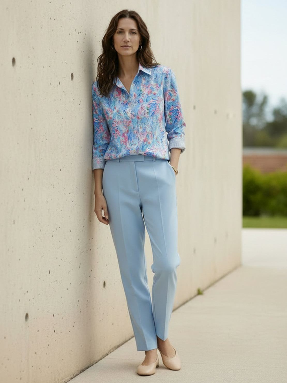 woman wearing floral button-down shirt with rolled-up sleeves and relaxed fit