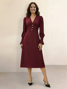 Woman wearing slimming V-neck midi dress with button-front and ruffle cuffs