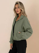 Cropped textured baseball jacket with full zipper, stand collar, elastic cuffs, and waistband, styled for casual wear.