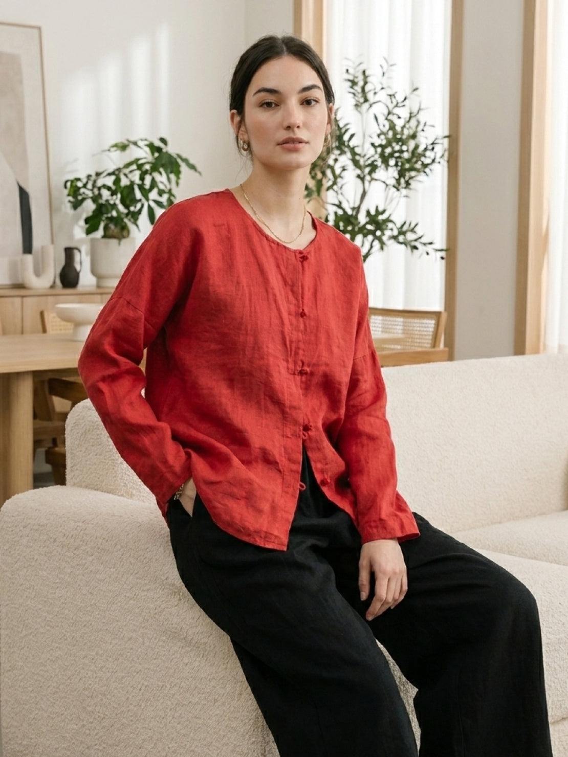 Woman wearing oversized 100% linen frog-button blouse with long sleeves and curved hem