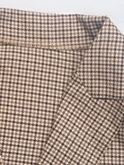 Classic houndstooth commuter blazer with structured shoulders, relaxed fit, notched lapel, and double-button closure.
