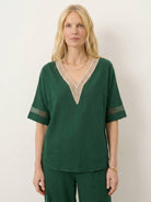 mature woman wearing lightweight linen top with V-neck and button detail in relaxed boxy shape