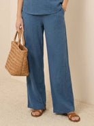 Mature woman wearing lightweight 100% linen short-sleeve V-neck top with button detail and relaxed boxy fit