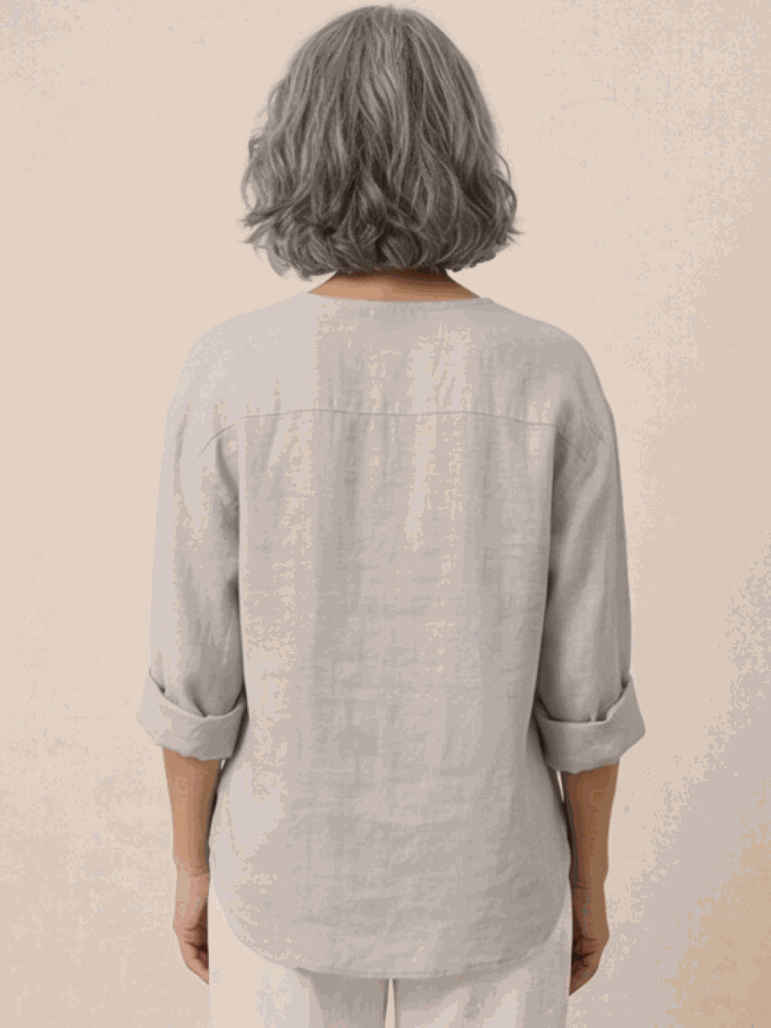 white pure linen age-defying shirt with button details hanging on wooden hanger