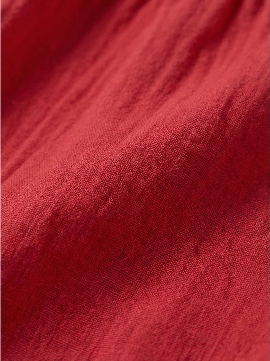 Woman wearing capped-sleeve voluminous pleated midi dress with flowing skirt and pockets