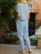 Woman wearing a relaxed cotton linen set with short-sleeve top and straight-leg pants in monochrome tones