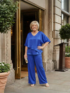 Woman wearing Elegant Layers Two-Piece Set featuring layered V-neck top and matching pants in soft polyester fabric