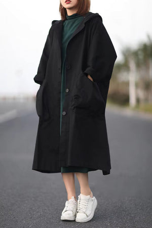 Oversized black waterproof windbreaker jacket with hood and large pockets, lightweight and longline design