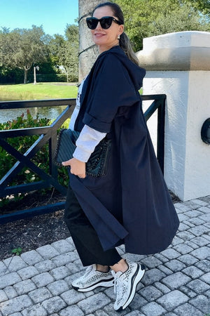 Woman wearing oversized water-resistant black windbreaker jacket with waterproof design outdoors