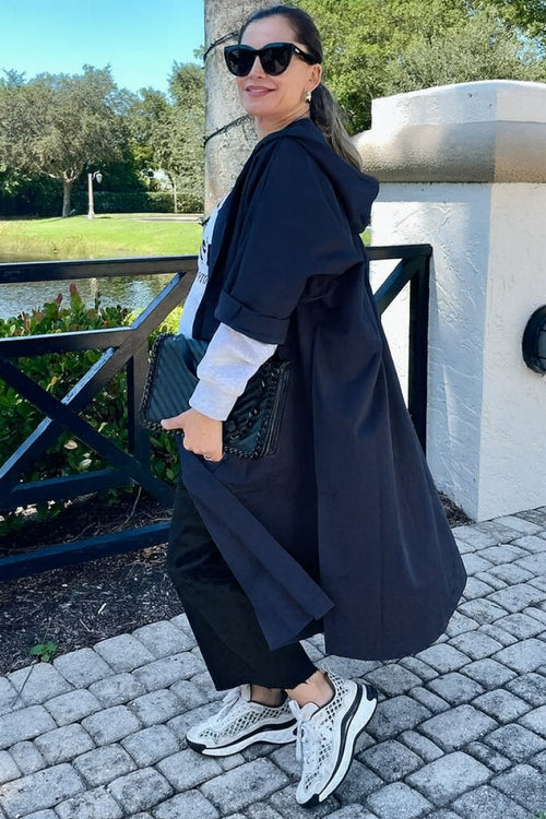 Woman wearing oversized water-resistant black windbreaker jacket with waterproof design outdoors