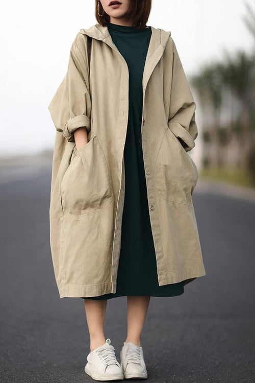 Oversized beige water-resistant windbreaker jacket with hood and large pockets, featuring a waterproof design.