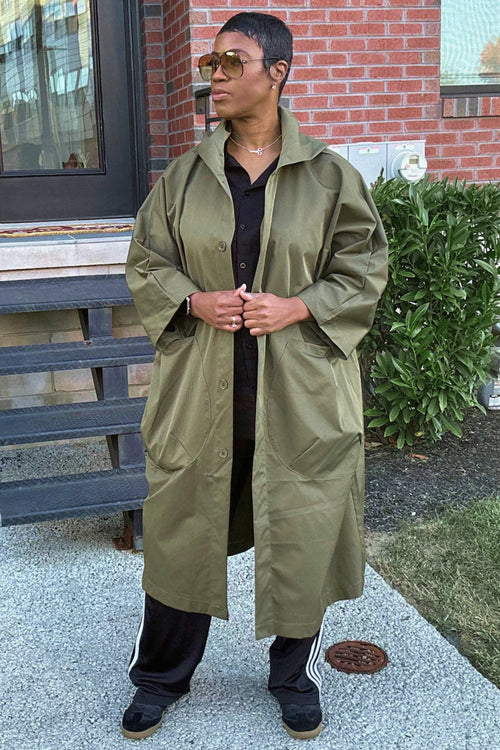 One size fits all oversized water-resistant windbreaker jacket with waterproof design, attached hood, snap-button closure, and large front pockets.