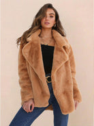 Woman wearing open front oversized faux fur jacket with draped shawl collar in camel color