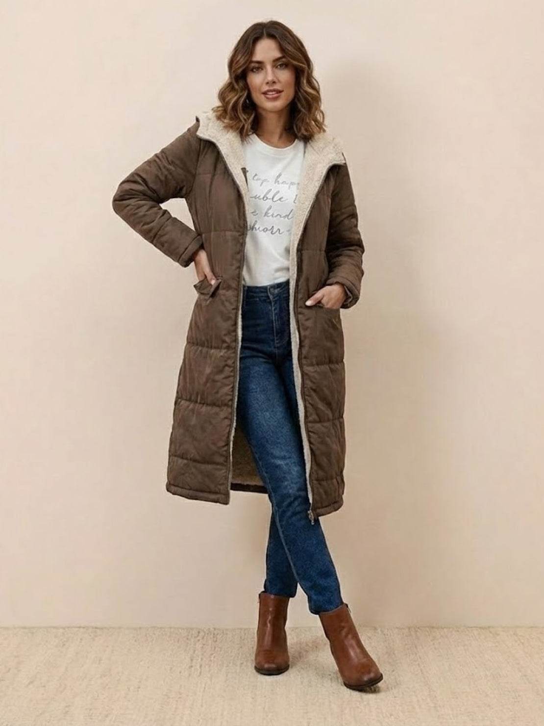 woman wearing brown sherpa-lined hooded teddy coat with pockets and blue jeans