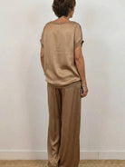 Model wearing Silken Escape Satin Two-Piece Set with flowing top and wide-leg pants in elegant satin fabric