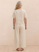 Woman wearing a relaxed loose fit co-ord set with soft-tailored top and wide-leg bottoms in solid color