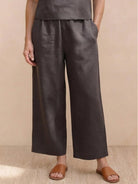 Woman wearing a relaxed loose fit co-ord set with soft-tailored top and wide-leg bottoms in neutral solid color