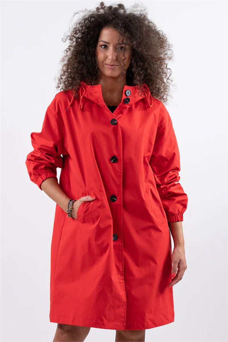 Woman wearing red Rain Couture Windbreaker oversized water-resistant jacket with hood and button closure